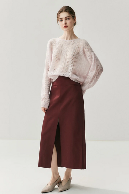 Woman wearing a light pink knitted sweater against a white background