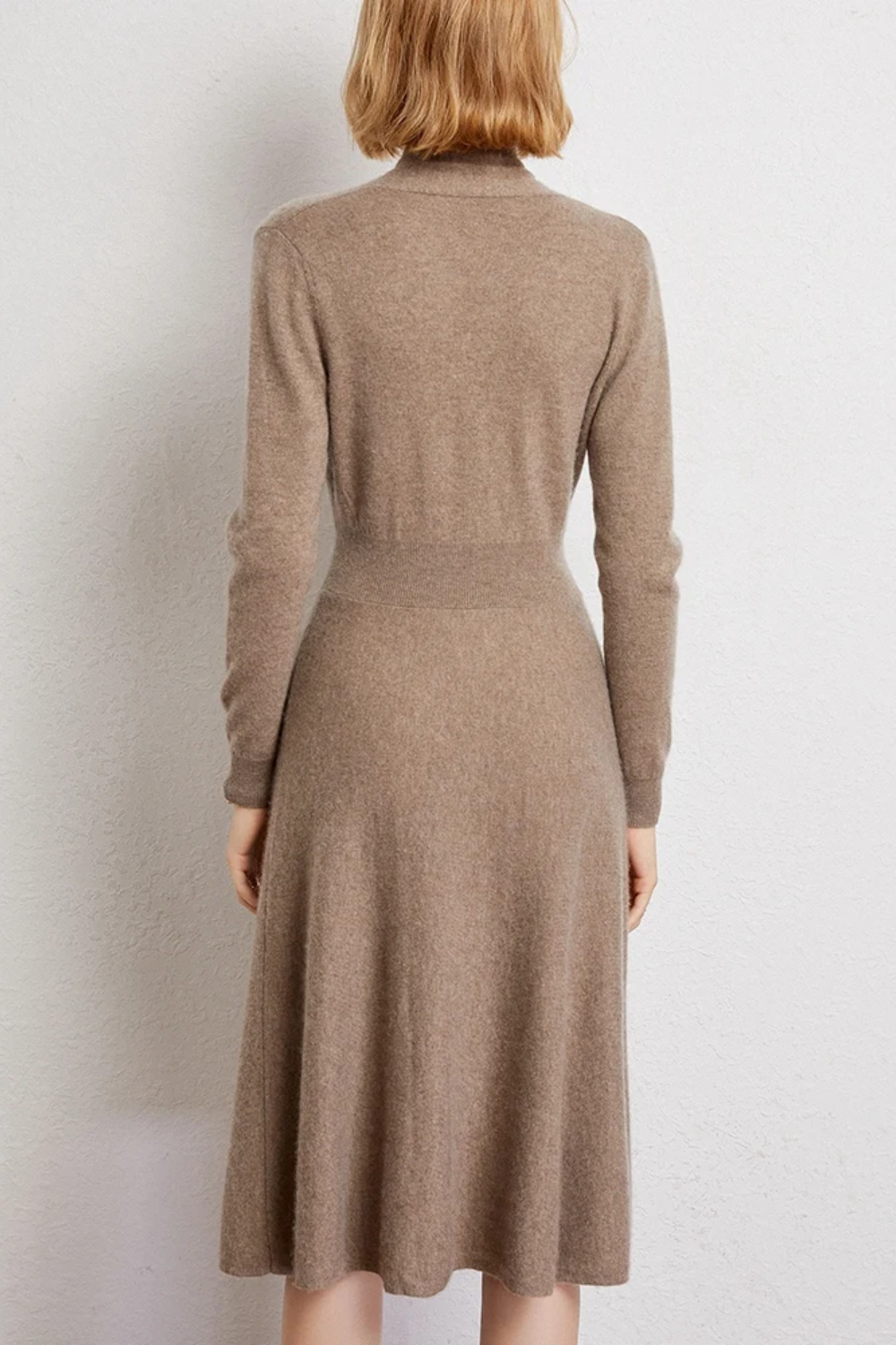 Woman wearing a beige coloured wrap dress with her back turned.