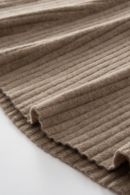 Close-up of a ribbed camel coloured dress on a light background