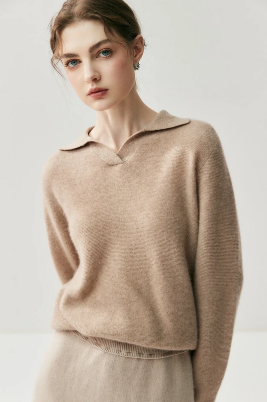 Woman wearing a camel coloured sweater against a plain background