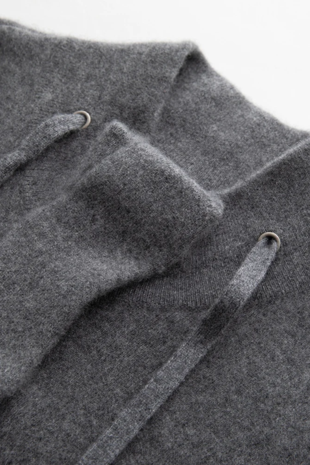 Close-up of a gray cardigan with drawstrings on a light gray background