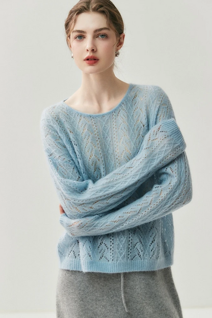Woman wearing a light blue knitted sweater against a white background