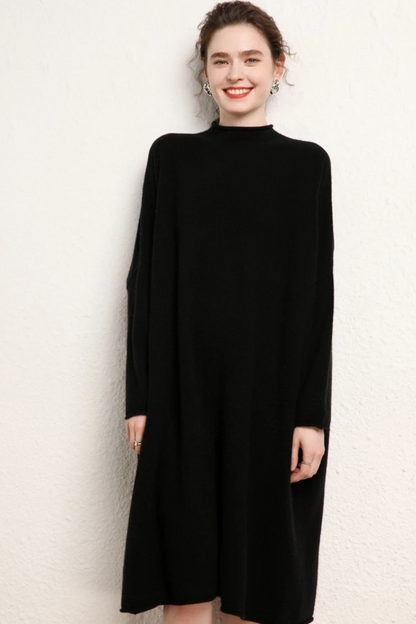 Woman wearing a black coloured dress against a plain background