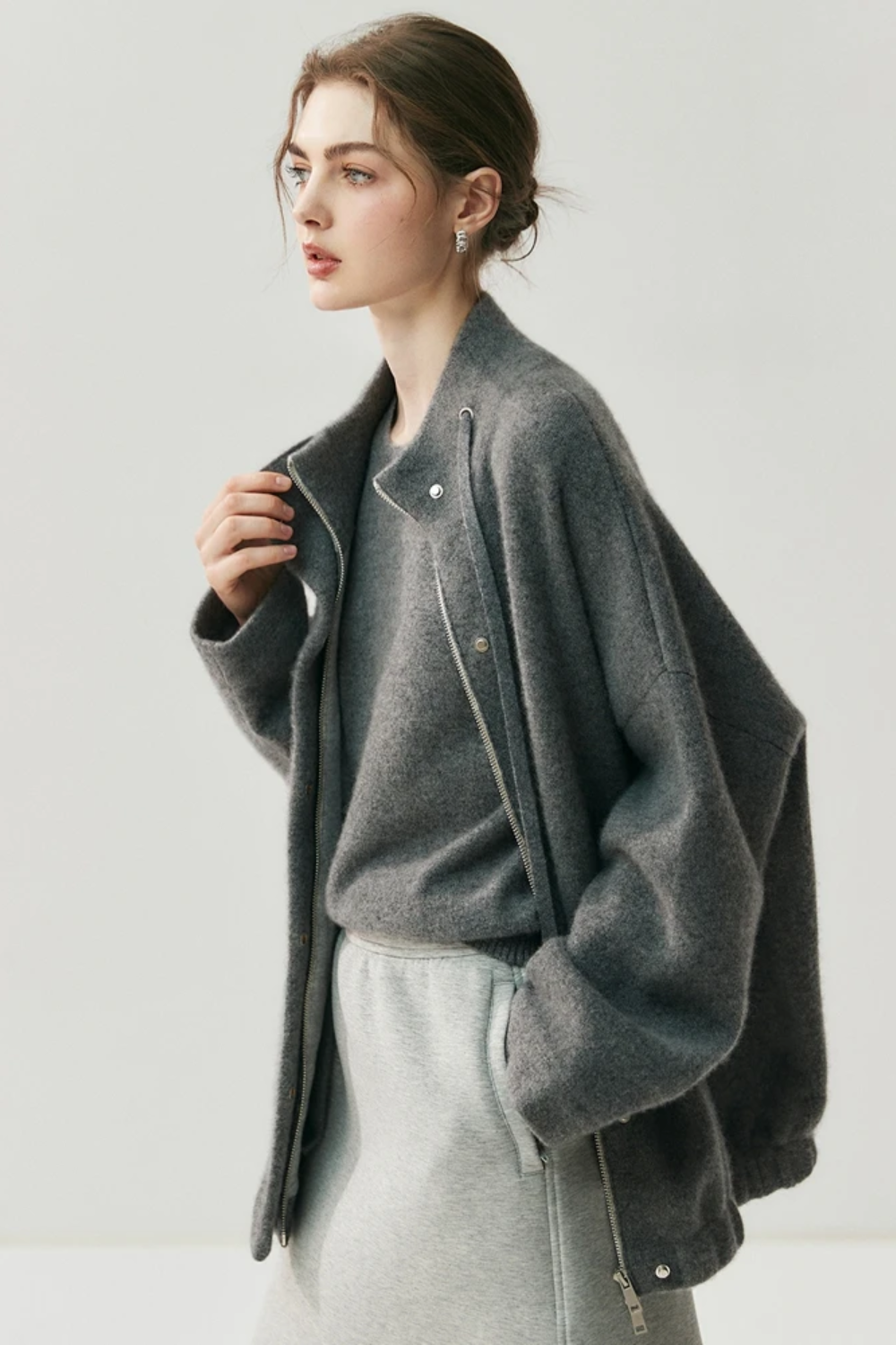 Woman wearing a gray cardigan on a white background