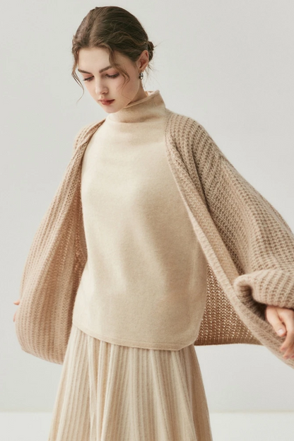 Woman wearing a camel knit cardigan and skirt on a white background