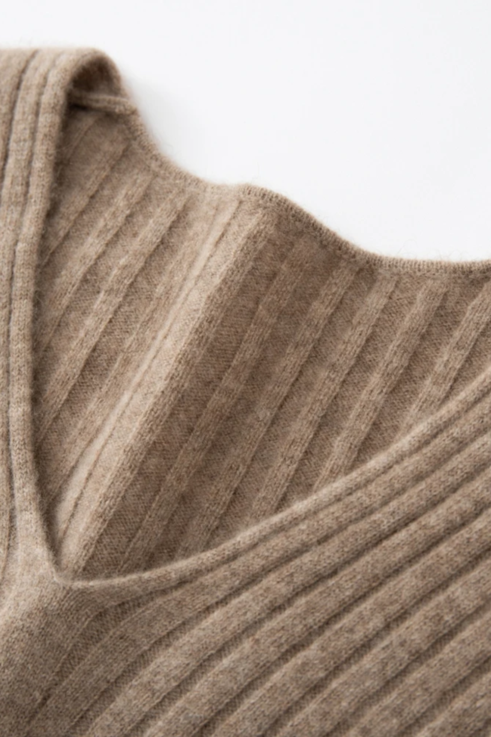 Close-up of a ribbed camel coloured sweater collar on a light background