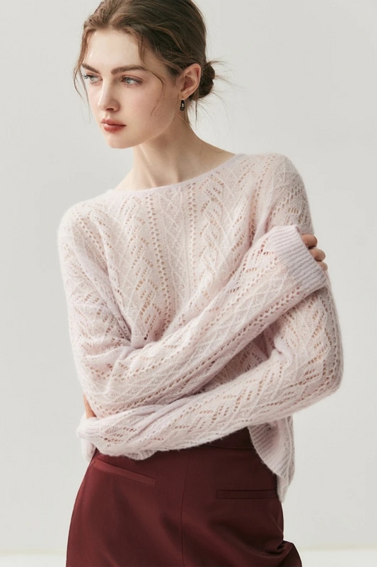 Woman wearing a light pink knitted sweater against a white background