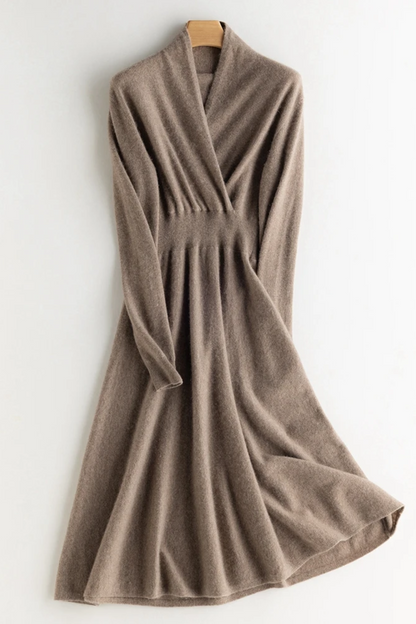 Beige wrap dress on a hanger against a white background