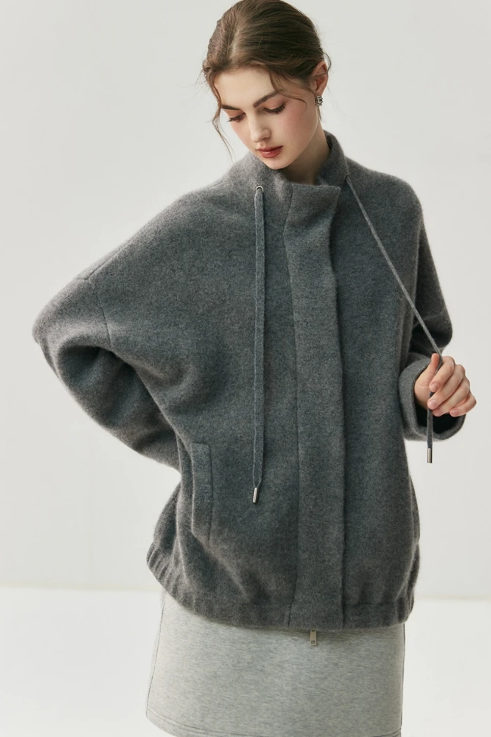 Woman wearing a gray cardigan on a white background