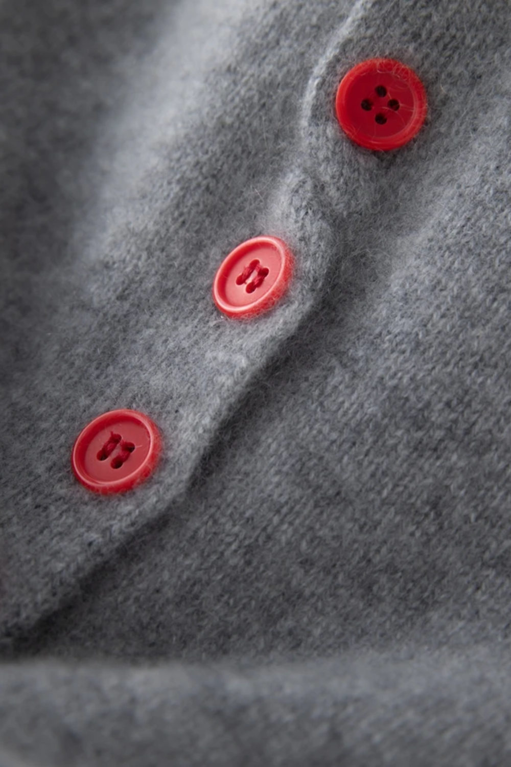 Close-up of a gray fabric with red buttons