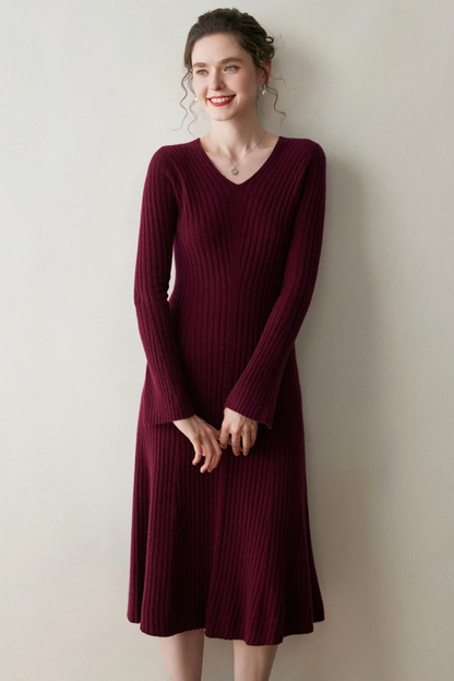 Woman wearing a burgundy ribbed dress against a plain background