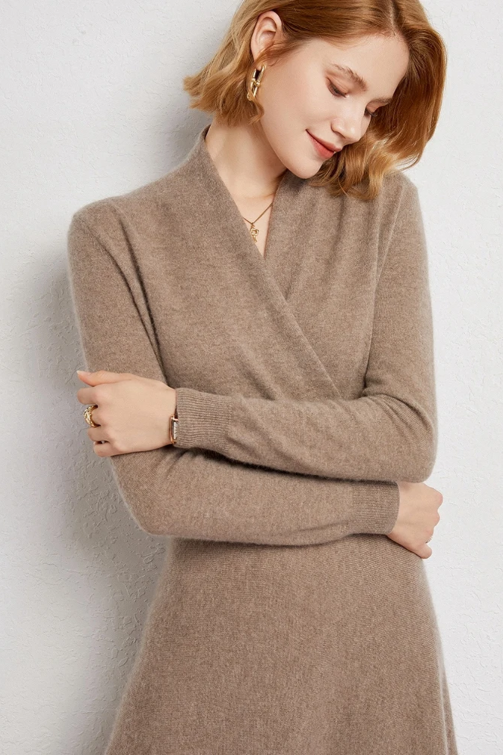 Woman wearing a beige wrap dress against a light background