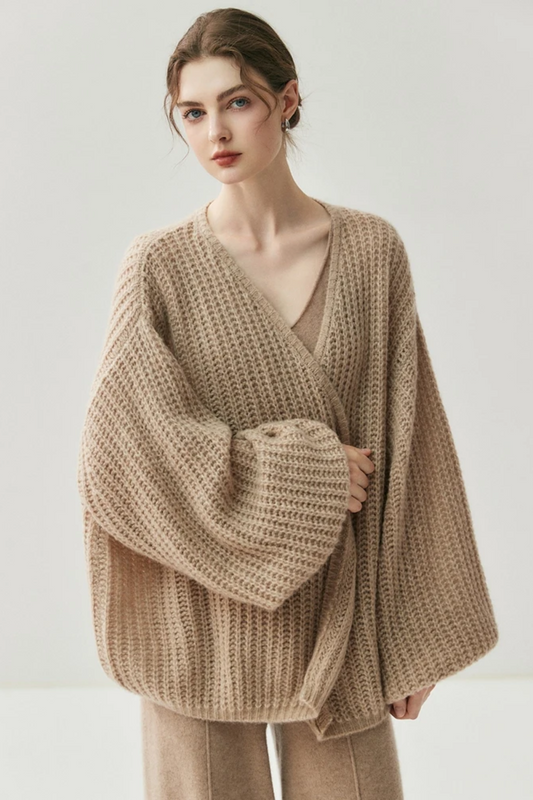 Woman wearing a camel knit cardigan and skirt on a white background