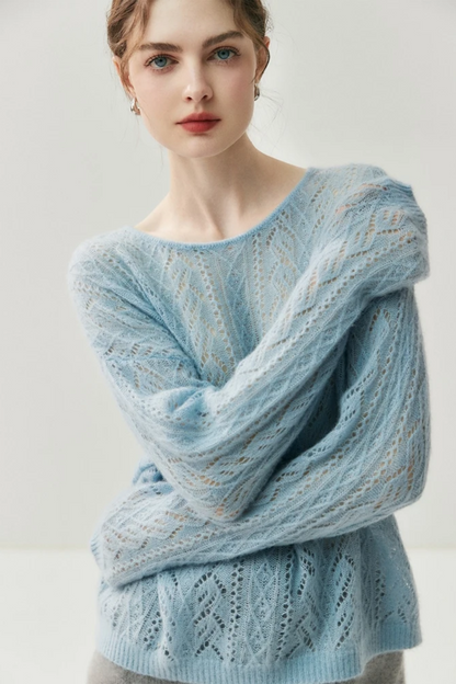 Woman wearing a light blue knitted sweater against a plain background