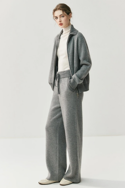 Person wearing a gray suit with a white shirt on a light gray background