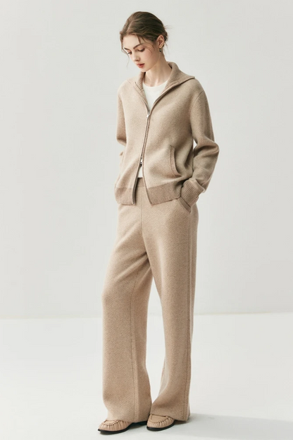 Woman wearing a camel cardigan and pants on a white background