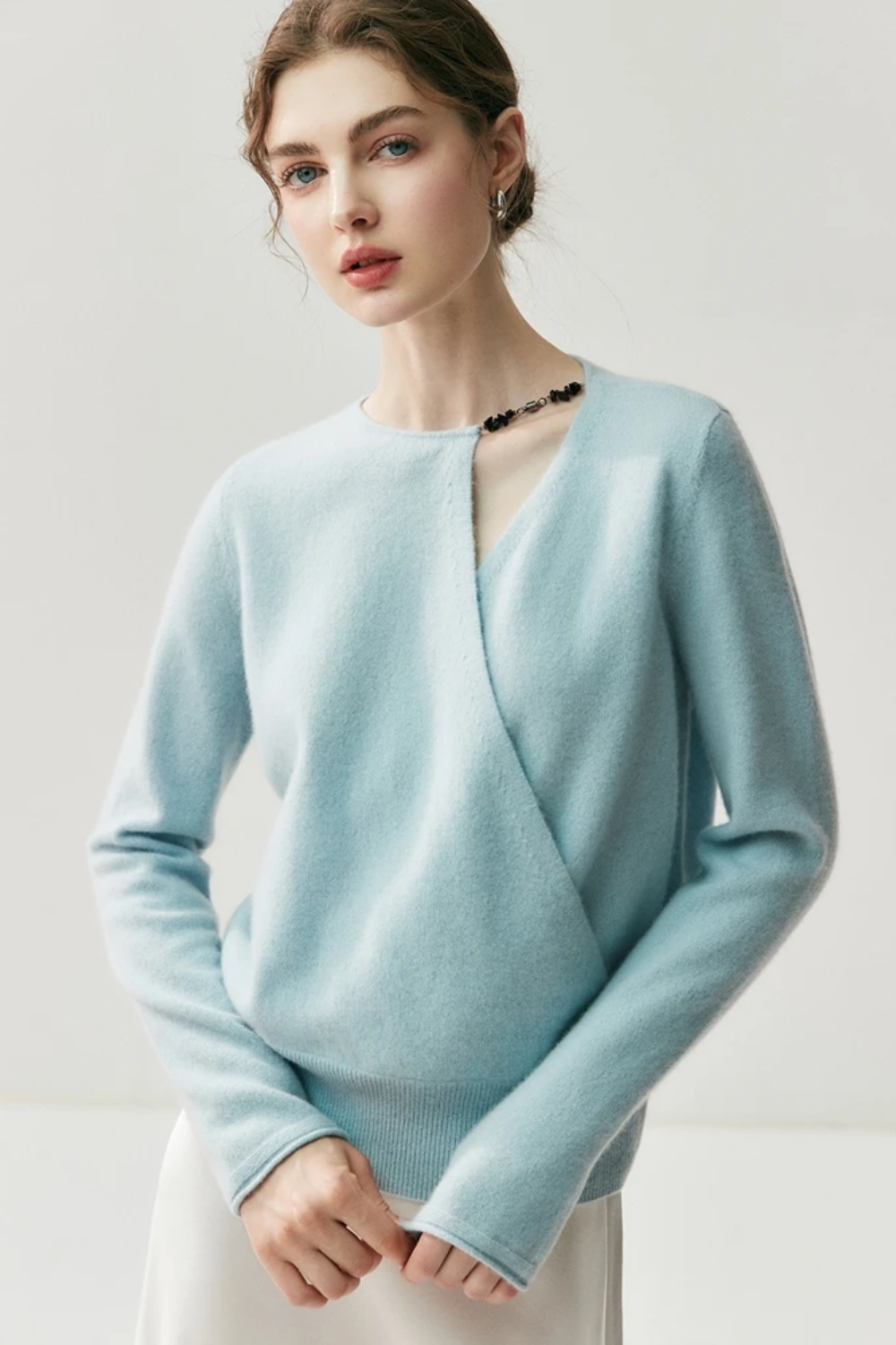 Light blue sweater worn by a model on a plain background