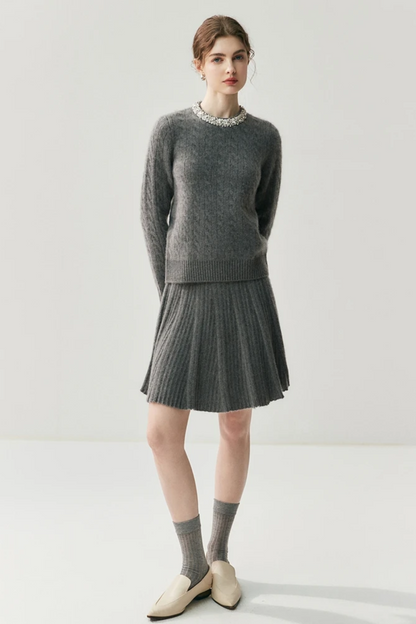Woman wearing a gray sweater and skirt set on a white background