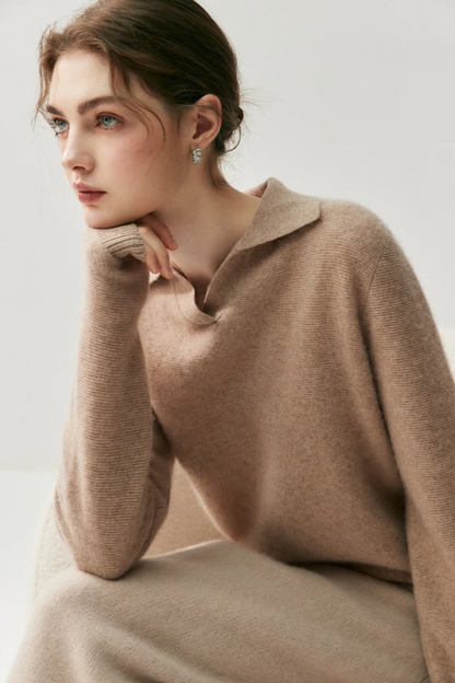 Woman wearing a camel coloured sweater against a plain background