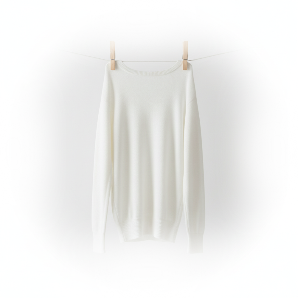 White cashmere shirt hanging on a clothesline against a white background