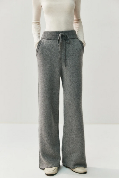 Person wearing gray drawstring pants on a white background