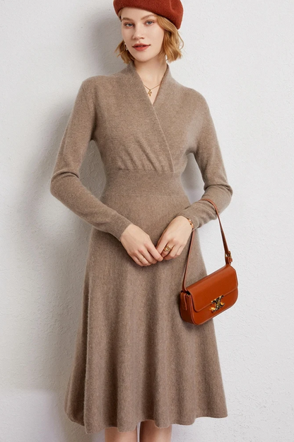 Woman wearing a beige wrap dress and red beret on a plain background