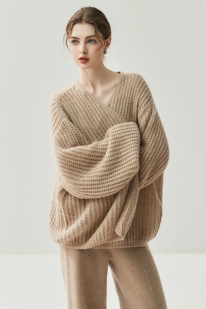 Woman wearing a camel knit cardigan and pants on a white background