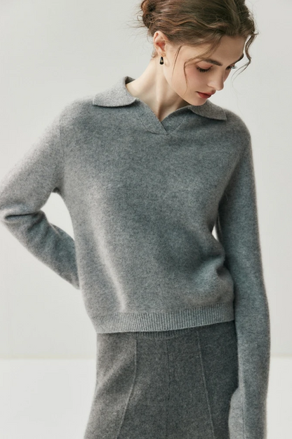 Woman wearing a gray sweater and pants against a white background