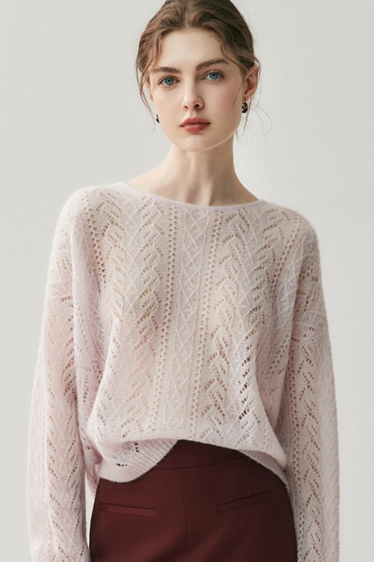 Woman wearing a light pink knitted sweater against a white background