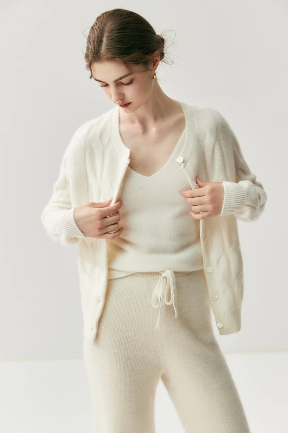 Woman wearing a white knit outfit on a white background