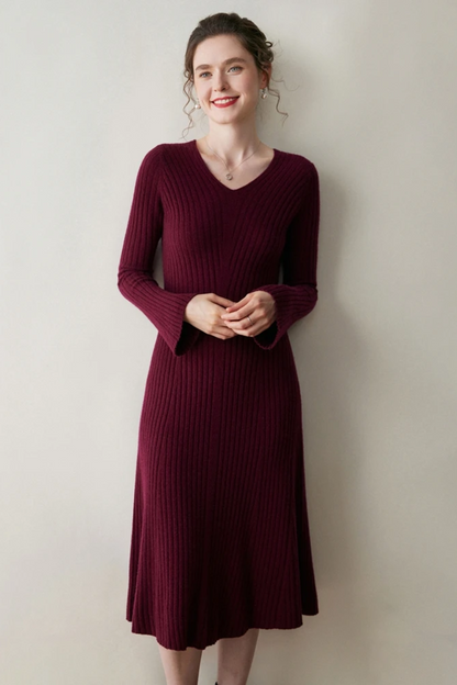 Woman wearing a burgundy ribbed dress against a plain background