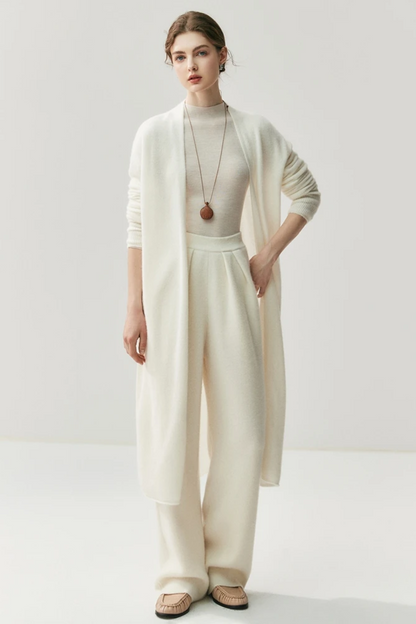 Woman wearing a white outfit with a ahite long cardigan on a white background