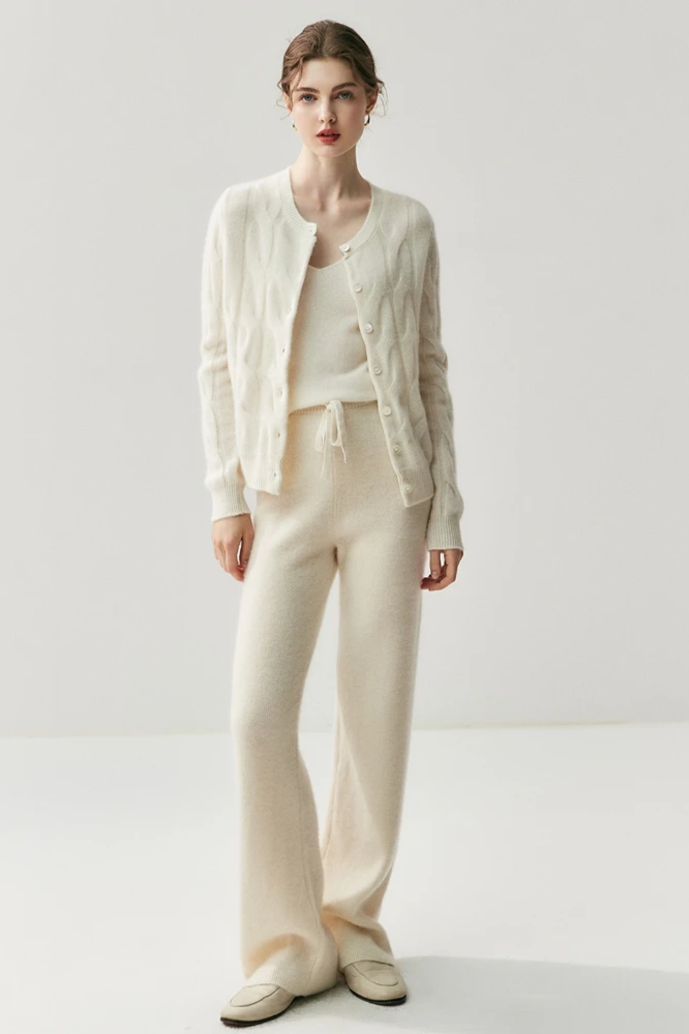 Woman wearing a white knit outfit on a white background