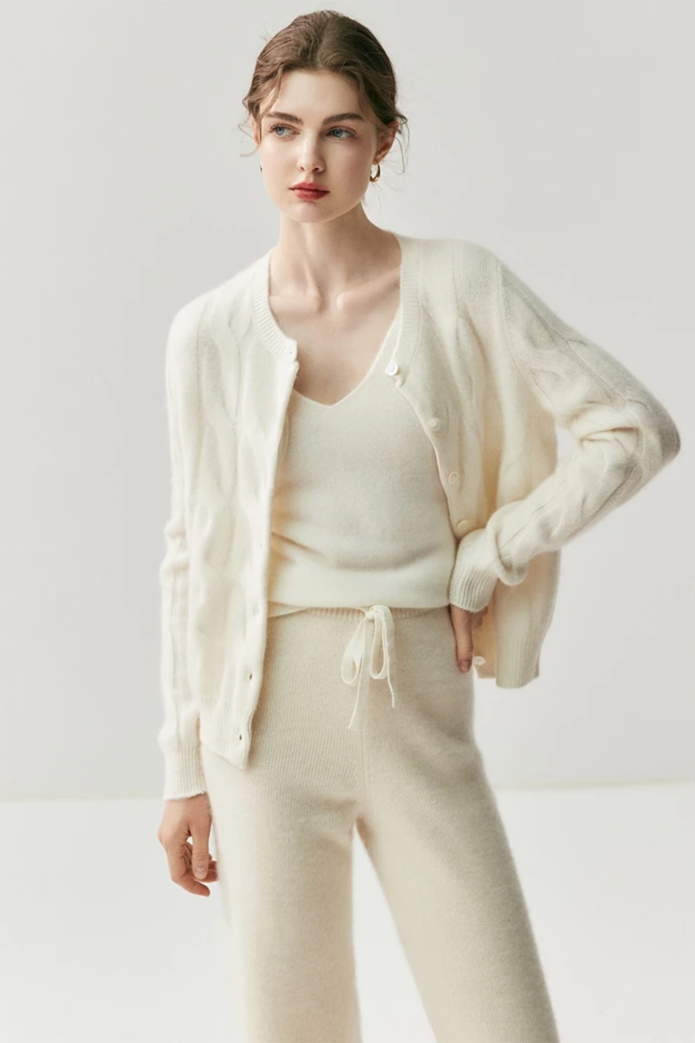 Woman wearing a white knit outfit on a white background