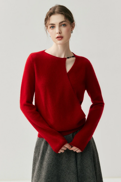 Woman wearing a red sweater with a cut out on the shoulder on a plain background