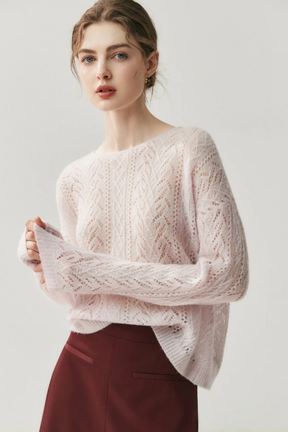 Woman wearing a light pink knitted sweater against a white background