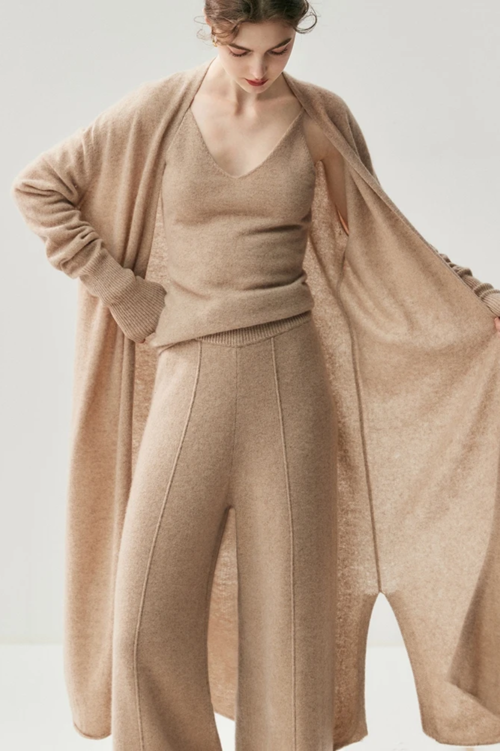 Woman wearing a camel sweater and pants set on a white background